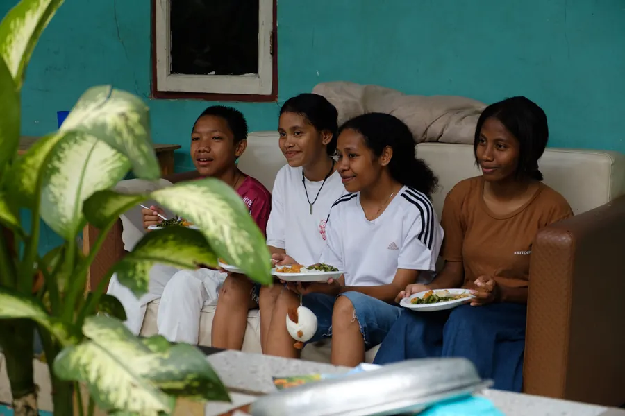 Remaja yayasan makan bersama di ruang tamu